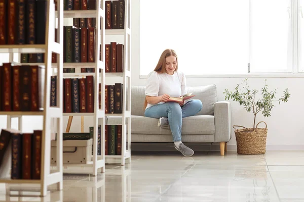 Junge Frau Liest Buch Auf Sofa Bibliothek — Stockfoto