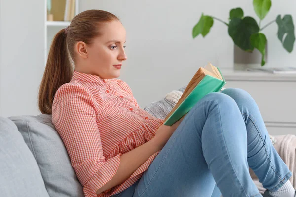 Молодая Женщина Читает Книгу Диване Дома — стоковое фото