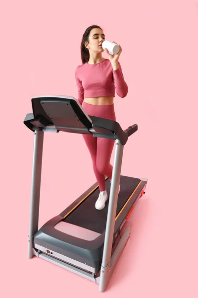 Sporty Young Woman Drinking Water Treadmill Pink Background — Stock Photo, Image