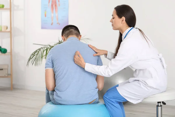 Doctora Comprobando Postura Del Joven Clínica —  Fotos de Stock