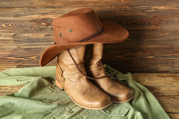 牛仔靴 帽子和木制背景衬衫 — 图库照片