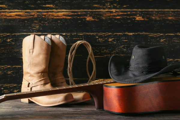 Stock image Cowboy hat, guitar and boots on wooden background