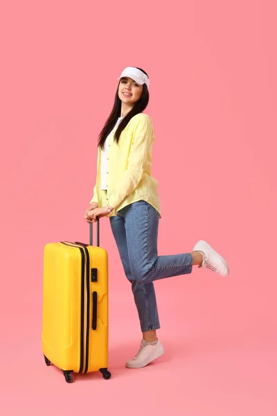 若いです女性とともにスーツケース上のピンクの背景 — ストック写真