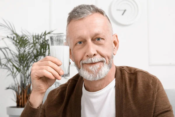 stock image Mature man with glass of milk at home, closeup