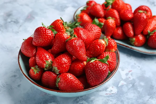 Schüssel Und Teller Mit Frischen Erdbeeren Auf Blauem Hintergrund — Stockfoto