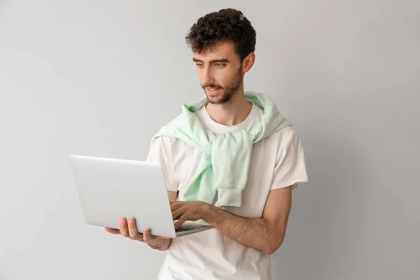 Młody Człowiek Pracujący Laptopem Jasnym Tle — Zdjęcie stockowe