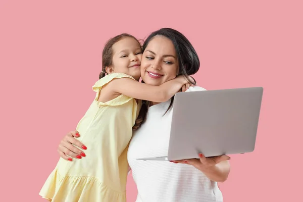 Working mother with her little daughter on pink background