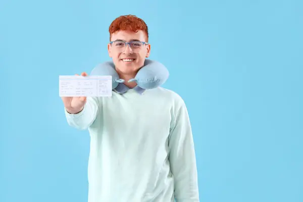 青い背景のチケットを持つ若い赤毛の男 — ストック写真