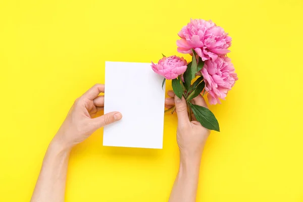 Női Kéz Üres Kártyával Gyönyörű Bazsarózsa Virágok Sárga Háttér — Stock Fotó