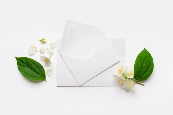 封筒と光の背景に美しいジャスミンの花の組成 — ストック写真