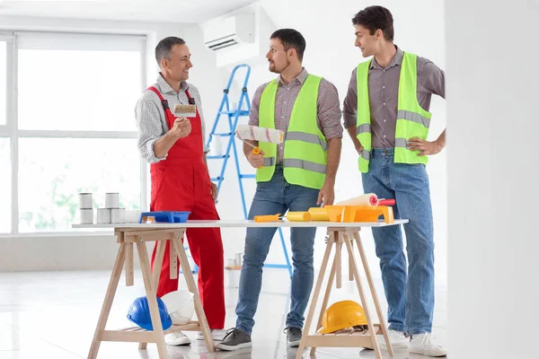 Equipo Constructores Masculinos Con Rodillos Pintura Trabajando Habitación —  Fotos de Stock