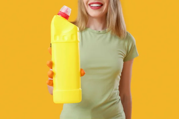 Młoda Kobieta Butelką Detergentu Pomarańczowym Tle Zbliżenie — Zdjęcie stockowe