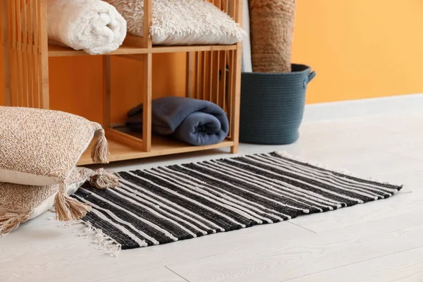 Stilvoller Teppich Kissen Und Regal Der Nähe Der Orangefarbenen Wand — Stockfoto