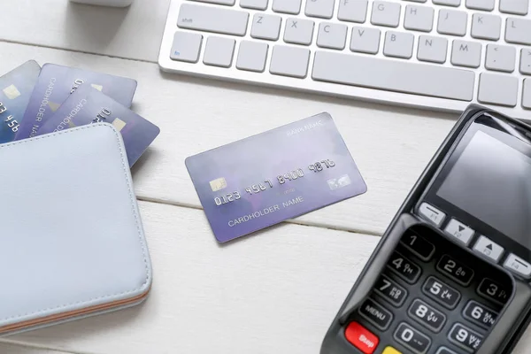 stock image Keyboard with payment terminal, wallet and credit cards on white wooden background