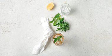 Bir bardak buzlu çay ve arka planda bulunan malzemeler.