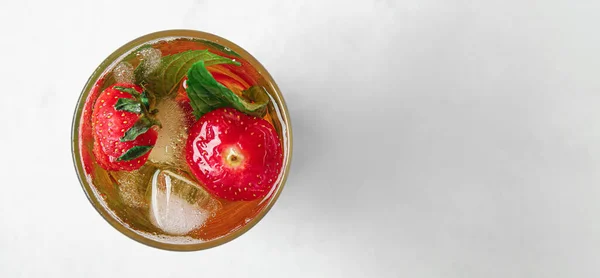 stock image Glass of ice tea with strawberry and mint on light background with space for text, top view