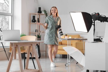 Stüdyoda profesyonel kameralı genç bayan fotoğrafçı.