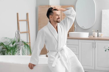 Banyoda saç dökülme sorunu olan yakışıklı bir adam.