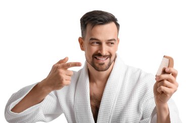 Saçları dökülme sorunu olan yakışıklı bir adam beyaz arka planı işaret ediyor.