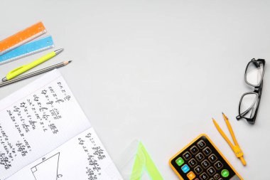 Matematik formülleri, hesap makinesi, gri arkaplan üzerindeki bardak ve kırtasiye defterleri