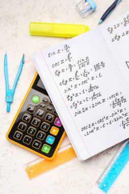 Matematik formülleri, hesap makinesi ve beyaz grunge arkaplanı üzerine kırtasiye defteri