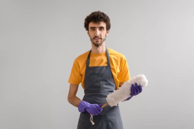 Gri arkaplanda pp-tozster olan genç adam