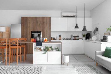 Ahşap masadaki modern aletlerle aydınlık mutfağın içinde.