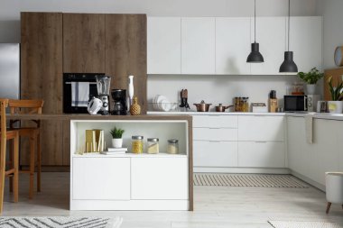 Ahşap masadaki modern aletlerle aydınlık mutfağın içinde.