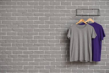 Gri duvarda asılı şık tişörtler