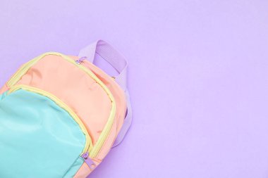 Mor arkaplanda renkli okul çantası