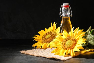 Siyah arka planda bir şişe ayçiçeği yağı.