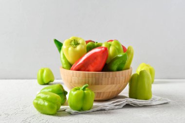 Beyaz arka planda farklı taze biberli ahşap kase.