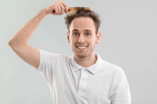 Молодий Чоловік Розчісує Волосся Сірому Фоні — стокове фото