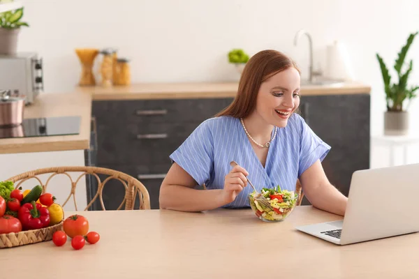 Giovane Donna Con Computer Portatile Mangiare Insalata Verdure Cucina — Foto Stock