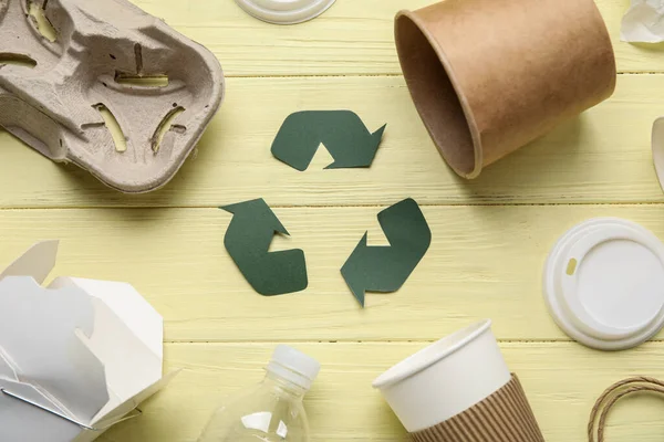 黄色の木製の背景にゴミとリサイクル記号 — ストック写真