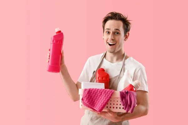ピンクの背景に物資を洗浄する若い男 — ストック写真