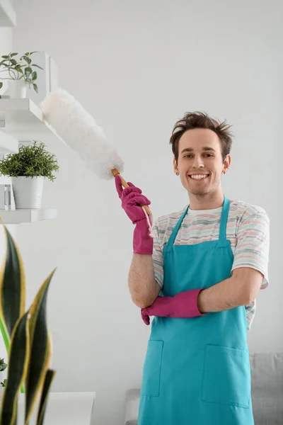 Young Man Wiping Dust Shelf Home — Stock Photo, Image