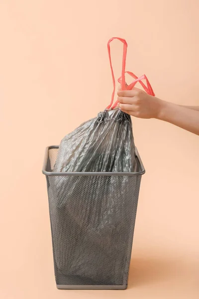 stock image Female hands taking full garbage bag from trash bin on beige background