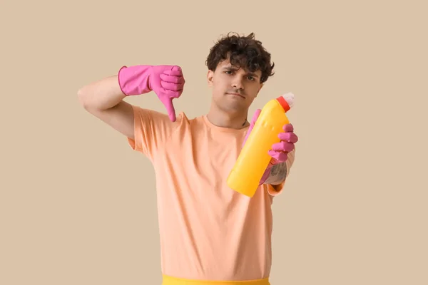 Joven Con Botella Detergente Mostrando Pulgar Hacia Abajo Sobre Fondo — Foto de Stock