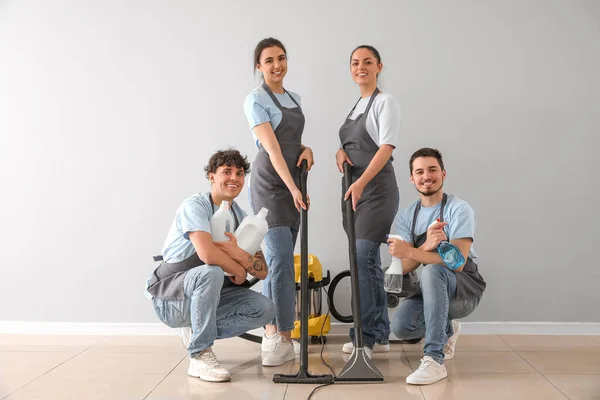 Young Janitors Cleaning Supplies Grey Wall — Stock Photo, Image