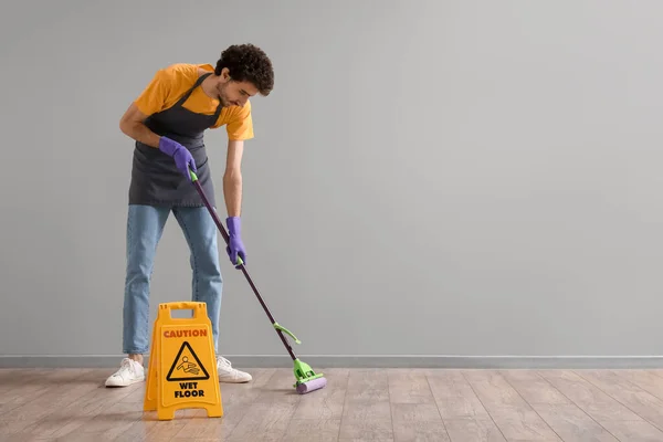 Young Man Mopping Floor Grey Wall — Stock Photo, Image