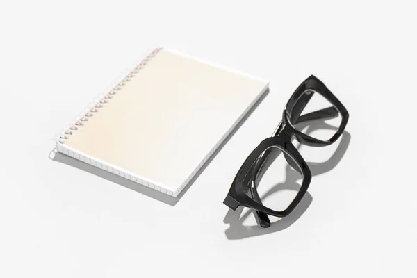 Notizbuch Und Schwarze Brille Auf Weißem Hintergrund — Stockfoto