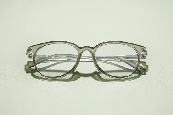 Óculos Cinzentos Elegantes Sobre Fundo Verde Pálido — Fotografia de Stock