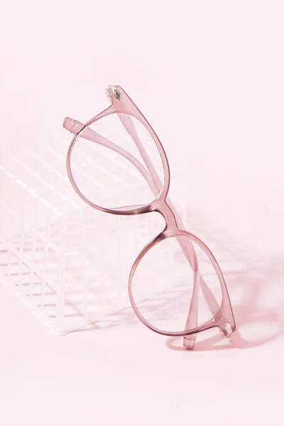 Stilvolle Brille Und Plastikschachtel Auf Blassrosa Hintergrund — Stockfoto