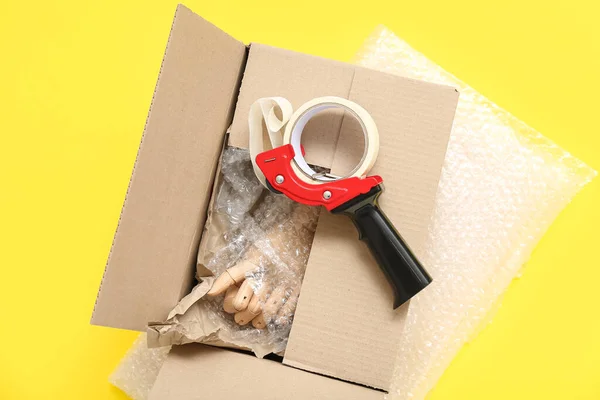 Sarı Arkaplanda Bant Karton Kutu Paketleniyor — Stok fotoğraf