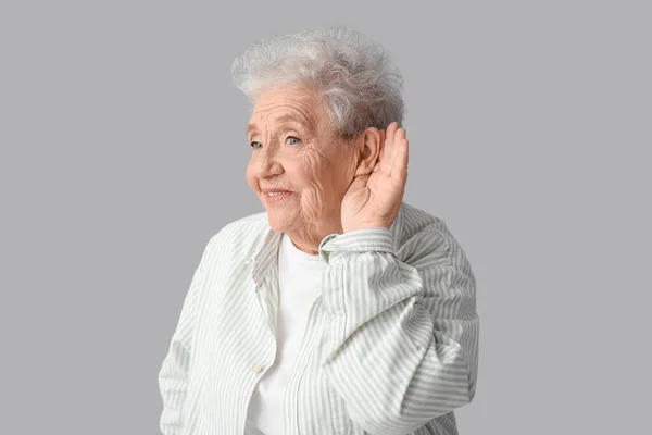 Senior Kvinna Försöker Höra Något Grå Bakgrund — Stockfoto