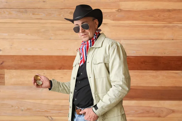 stock image Mature cowboy with compass on wooden background