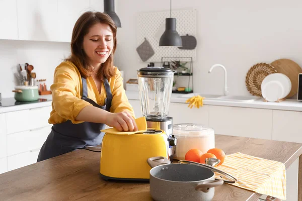 Mutfakta Genç Bir Kadın Ahşap Masada Tost Makinesini Temizliyor — Stok fotoğraf