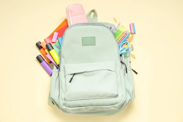 Зелений Шкільний Рюкзак Різними Канцтоварами Блідо Жовтому Фоні — стокове фото