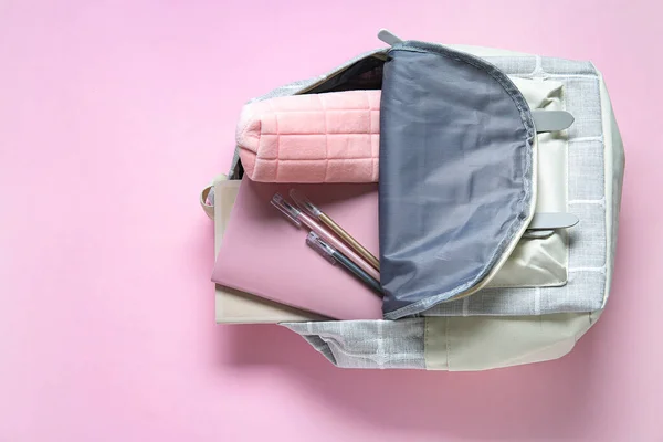 粉色背景的不同文具的彩色校服背包 — 图库照片